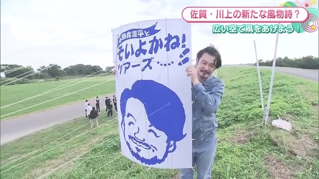 小田井良平さんの似顔絵が描かれた凧を抱える小田井良平さん